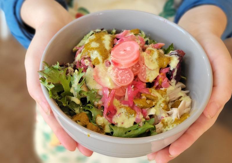Garden bowl with greens, pickles, and sauce